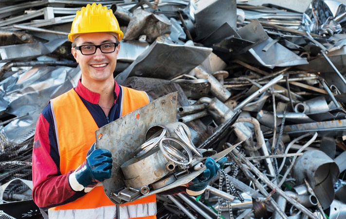 Mitarbeiter mit Metallmaterialien auf einem Schrottplatz